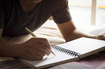 Teen boy writing notes