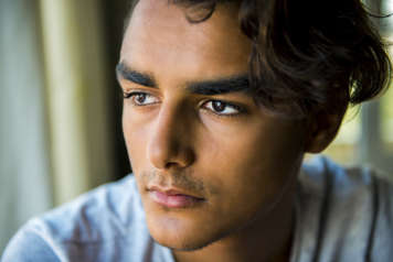 Portrait of teen looking to the side with a slight frown and slightly downturned mouth