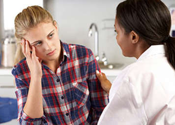 Healthcare professional comforting teen patient